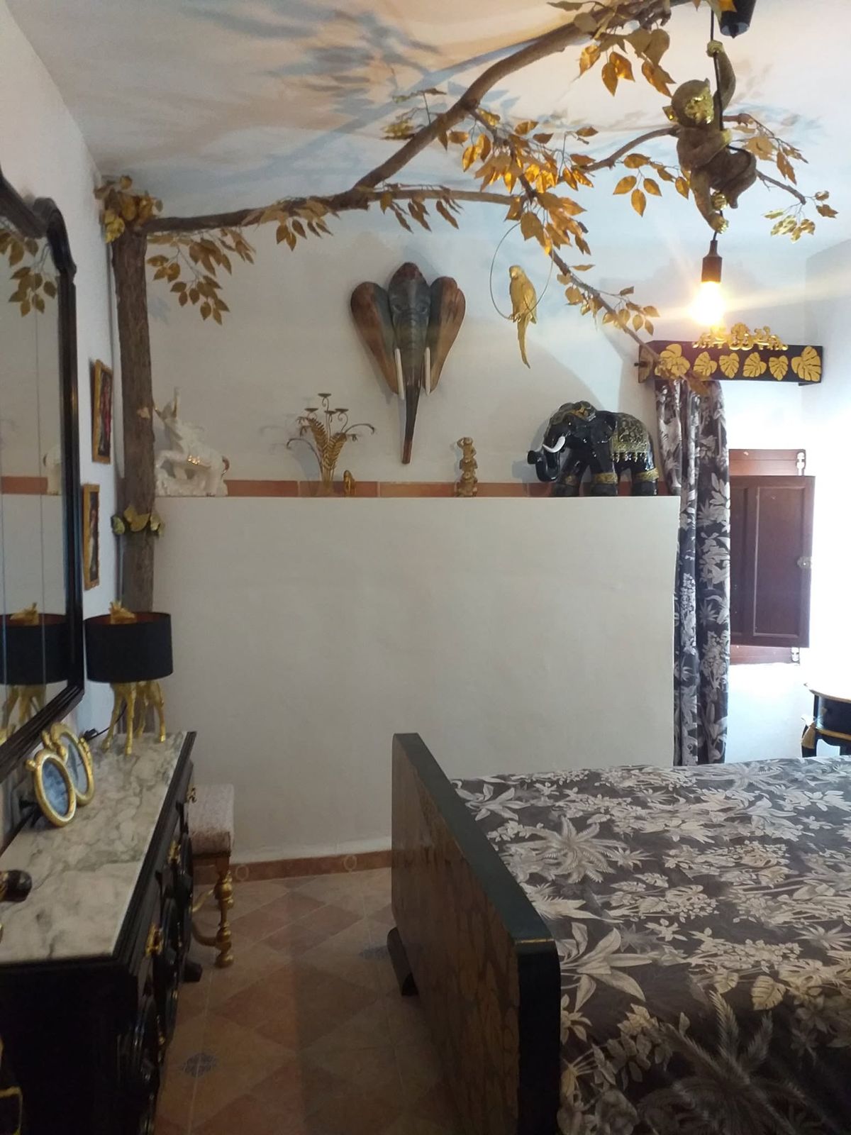 Jungle room with a golden-leaf tree across the ceiling